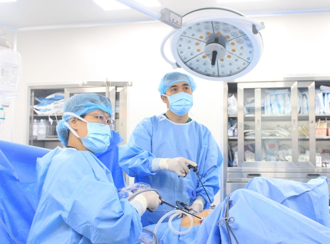 Bác sĩ phẫu thuật nội soi lấy thai lạc trong ổ bụng chị Nhung. Ảnh: Tuệ Diễm